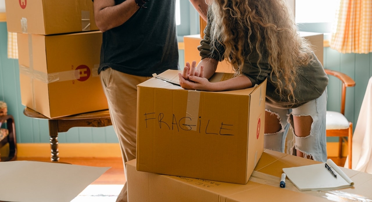 cropped man and woman discussing moving over a box marked fragile