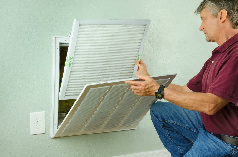 Man replacing an air filter in a home