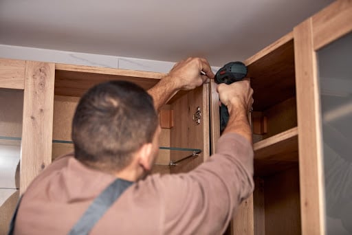 carpenter working on wood cabinets